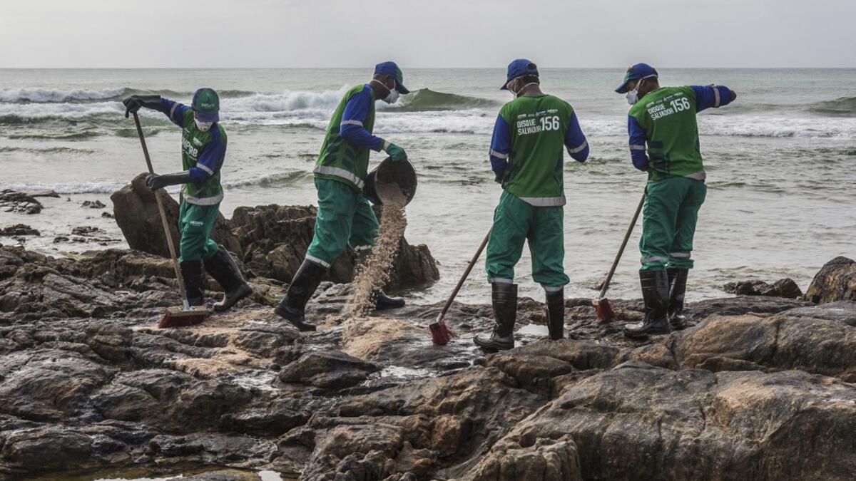 Municipal workers remove spilled crude oil at Pedra do Sal beach in Salvador, Bahia state, Brazil, on October 23, 2019. Large blobs of oil staining more than 130 beaches in northeastern Brazil began appearing in early September and have now turned up along a 2,000km stretch of the Atlantic coastline. The source of the patches remain a mystery despite President Jair Bolsonaro's assertions they came from outside the country and were possibly the work of criminals. ANTONELLO VENERI / AFP