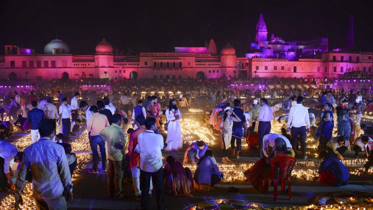 Hindu devotees light earthen lamps on the banks of the River Sarayu on the eve of "Diwali" festival during an event organised by the Uttar Pradesh government, in Ayodhya on October 26, 2019. "Diwali", the Festival of Lights, marks victory over evil and commemorates the time when Hindu god Lord Rama achieved victory over Ravana and returned to his kingdom Ayodhya. SANJAY KANOJIA / AFP