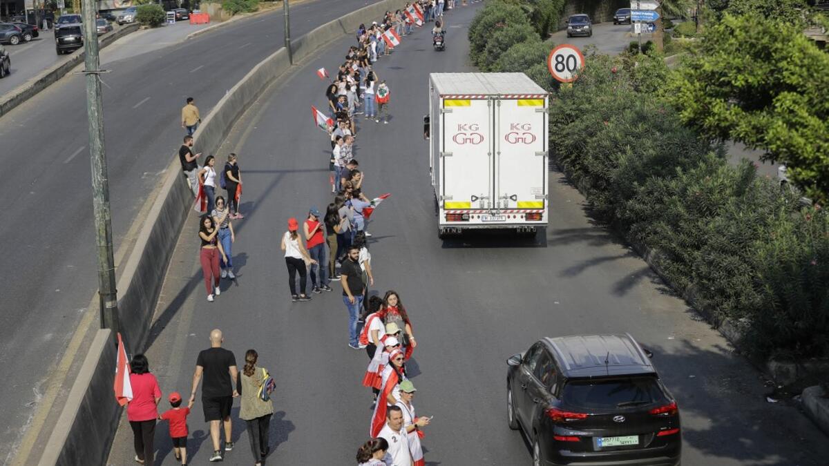 Lebanese protesters hold hands to form a human chain along the coast from north to south as a symbol of unity during ongoing anti-government demonstrations on Jounieh highway north of Lebanon's capital Beirut on October 27, 2019. JOSEPH EID / AFP