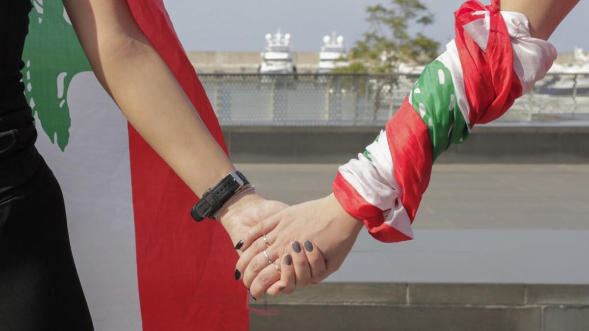 Lebanese protesters hold hands to form a human chain along the coast from north to south as a symbol of unity, during ongoing anti-government demonstrations in Lebanon's capital Beirut on October 27, 2019. ANWAR AMRO / AFP