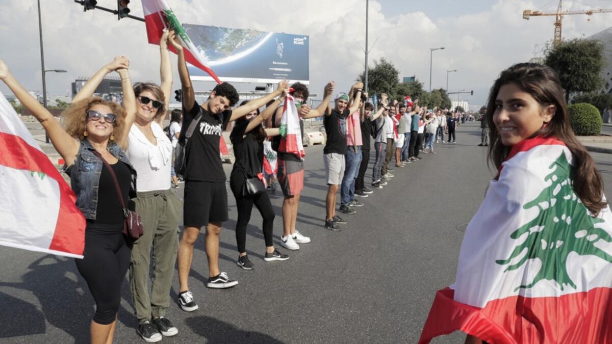 Lebanese protesters hold hands to form a human chain along the coast from north to south as a symbol of unity, during ongoing anti-government demonstrations in Lebanon's capital Beirut on October 27, 2019. ANWAR AMRO / AFP
