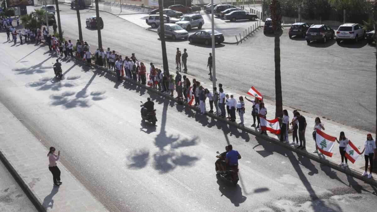 Lebanese protesters hold hands to form a human chain along the coast from north to south as a symbol of unity, during ongoing anti-government demonstrations in the southern Lebanese port city of Sidon on October 27, 2019. Mahmoud ZAYYAT / AFP