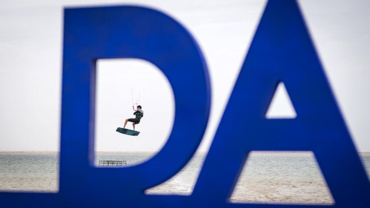 A picture taken on October 10, 2019, shows a kitesurfer performing a jump at Dakhla beach in Morocco-administered Western Sahara. In the heart of disputed Western Sahara, a former garrison town has become an unlikely tourist magnet after kitesurfers discovered the windswept desert coast on the Atlantic is perfect for their sport. FADEL SENNA / AFP