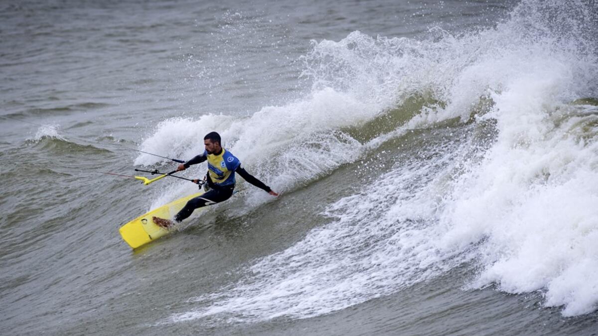A picture taken on October 10, 2019, shows a kitesurfer riding waves at Dakhla beach in Morocco-administered Western Sahara. In the heart of disputed Western Sahara, a former garrison town has become an unlikely tourist magnet after kitesurfers discovered the windswept desert coast on the Atlantic is perfect for their sport. FADEL SENNA / AFP
