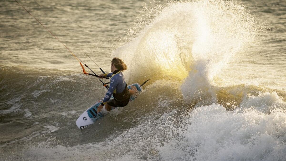 A picture taken on October 10, 2019, shows a kitesurfer riding waves at Dakhla beach in Morocco-administered Western Sahara. In the heart of disputed Western Sahara, a former garrison town has become an unlikely tourist magnet after kitesurfers discovered the windswept desert coast on the Atlantic is perfect for their sport. FADEL SENNA / AFP