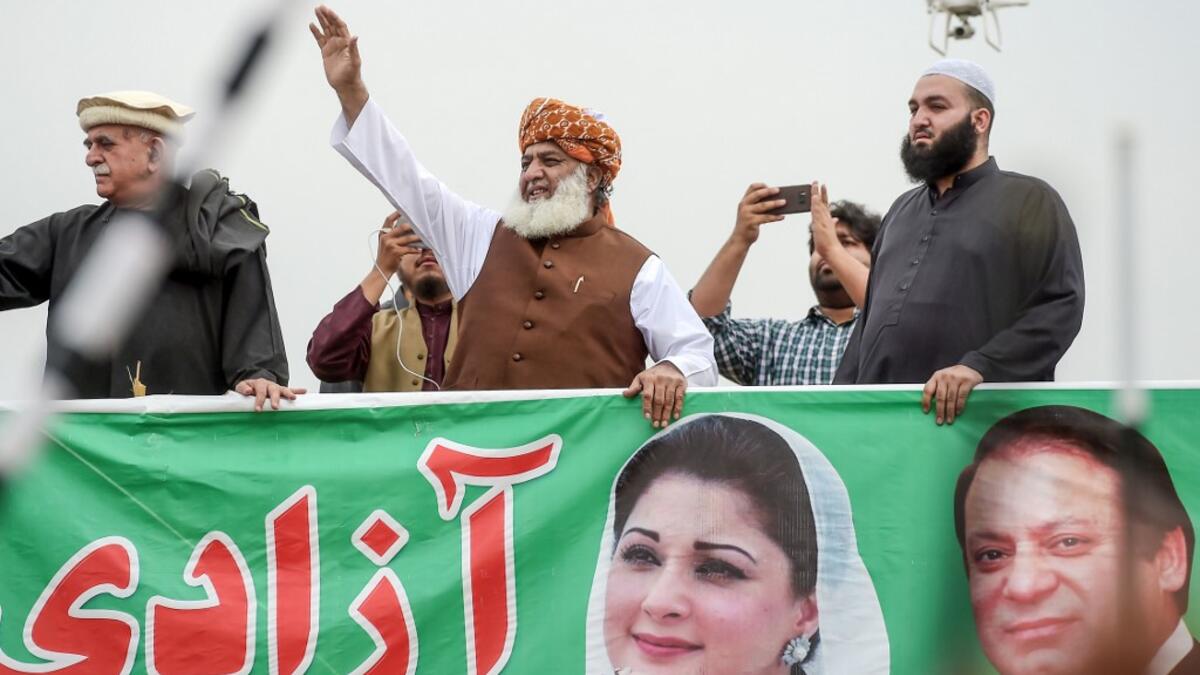 Islamic political party Jamiat Ulema-e-Islam (JUI-F) leader Maulana Fazlur Rehman (C) waves during an anti-government an "Azadi (Freedom) March" in Islamabad. Thousands of Islamists rallied in Islamabad on November 1 as several huge marches from across Pakistan converged on the capital to demand that Prime Minister Imran Khan's government step down. AAMIR QURESHI / AFP