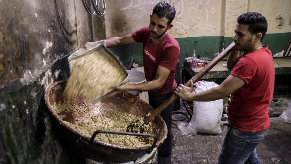 Egyptian confectioners add peanuts to melted sugar as they make sweets at a candy factory in the capital Cairo on November 2, 2019, ahead of celebrations of the Muslim Prophet Mohammed's birthday, known as "Al Mawlid Al Nabawi". Prophet Mohamed was born in Saudi Arabia's arid mountainous city of Mecca, the holiest in Islam, some 1490 years ago. Sunni Muslims in many parts of the world celebrate his birthday on the 12th day of the third month of the Islamic calendar, which will fall this year on November 9th