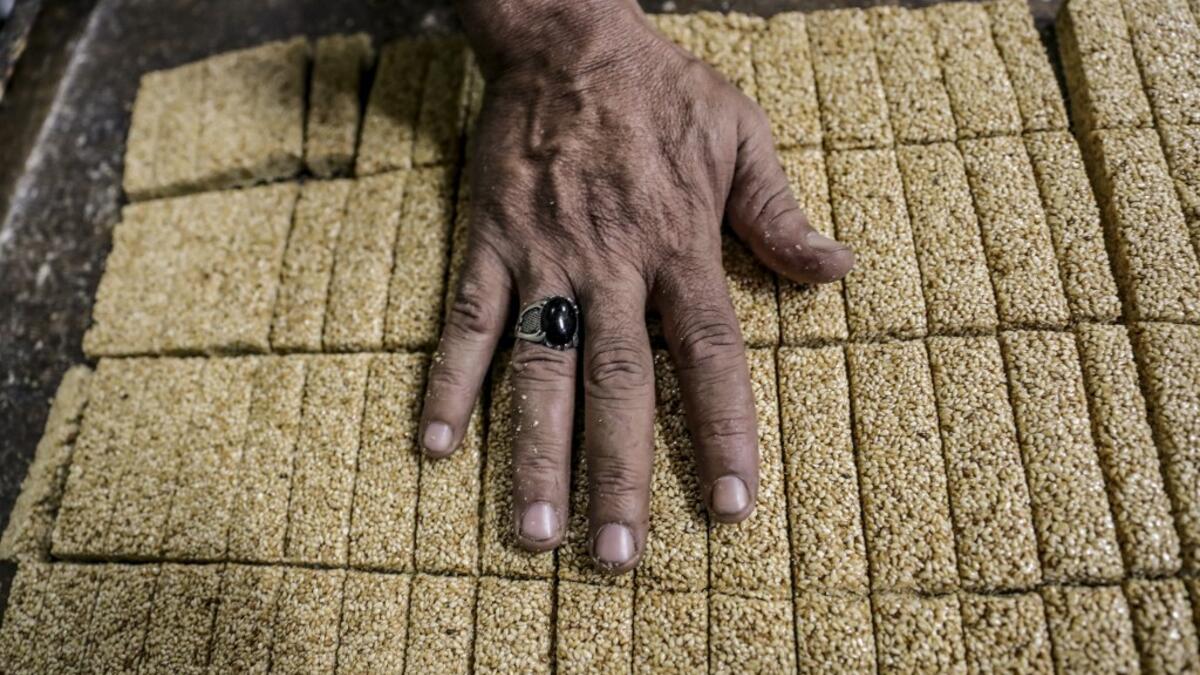An Egyptian confectioner shows bars of sweets with sesame at a candy factory in the capital Cairo on November 2, 2019, ahead of celebrations of the Muslim Prophet Mohammed's birthday, known as "Al Mawlid Al Nabawi". Prophet Mohamed was born in Saudi Arabia's arid mountainous city of Mecca, the holiest in Islam, some 1490 years ago. Sunni Muslims in many parts of the world celebrate his birthday on the 12th day of the third month of the Islamic calendar, which will fall this year on November 9th.  Mohamed el