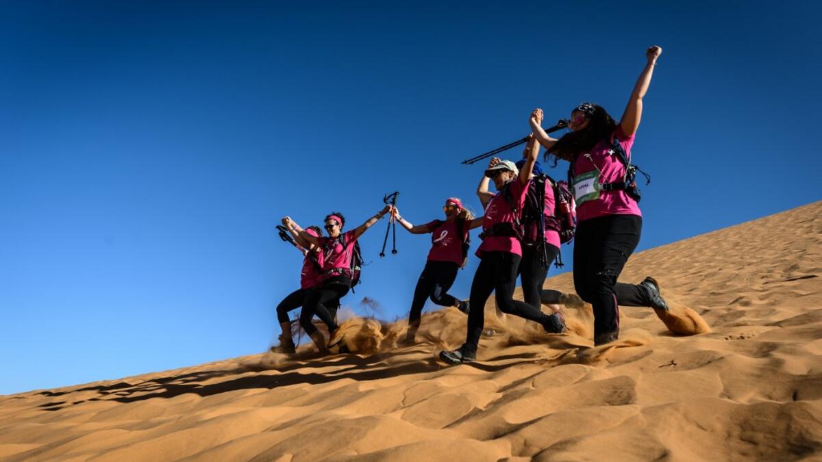 Women run down a sand dune as they take part in the desert trek "Rose Trip Maroc", on November 4, 2019 in the erg Chebbi near Merzouga. The Rose Trip Maroc is a female-oriented trek where teams of three must travel through the southern Moroccan Sahara desert with a compass, a map and a topographical reporter. JEAN-PHILIPPE KSIAZEK / AFP