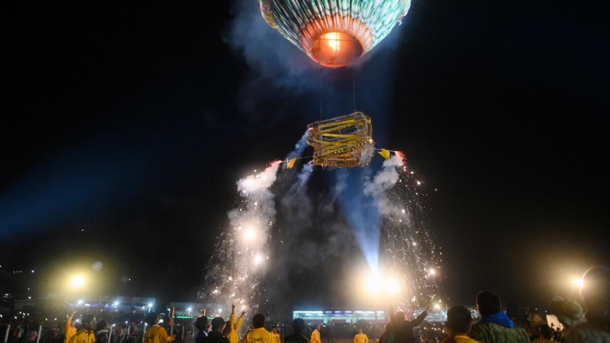 This picture taken on November 4, 2019 shows participants releasing a hot-air balloon attached with fireworks during the Tazaungdaing Lighting Festival at Taunggyi in Myanmar's northeastern Shan State. Brightly coloured balloons with hundreds of homemade fireworks woven into their frames are sent soaring into the night sky, showering down cascades of sparks onto adoring crowds in the annual Taunggyi fire balloon festival. Ye Aung THU / AFP