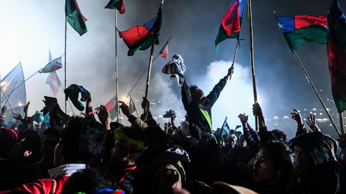 This picture taken on November 5, 2019 shows participants celebrating as fireworks explode after they released a hot-air balloon attached with fireworks during the Tazaungdaing Lighting Festival at Taunggyi in Myanmar's northeastern Shan State. Brightly coloured balloons with hundreds of homemade fireworks woven into their frames are sent soaring into the night sky, showering down cascades of sparks onto adoring crowds in the annual Taunggyi fire balloon festival. Ye Aung THU / AFP