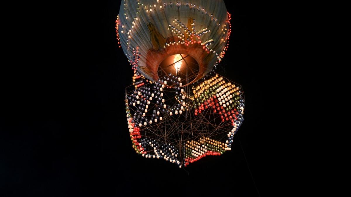 This picture taken on November 6, 2019 shows a hot-air balloon attached with fireworks taking off during the Tazaungdaing Lighting Festival at Taunggyi in Myanmar's northeastern Shan State. Brightly coloured balloons with hundreds of homemade fireworks woven into their frames are sent soaring into the night sky, showering down cascades of sparks onto adoring crowds in the annual Taunggyi fire balloon festival. Ye Aung THU / AFP