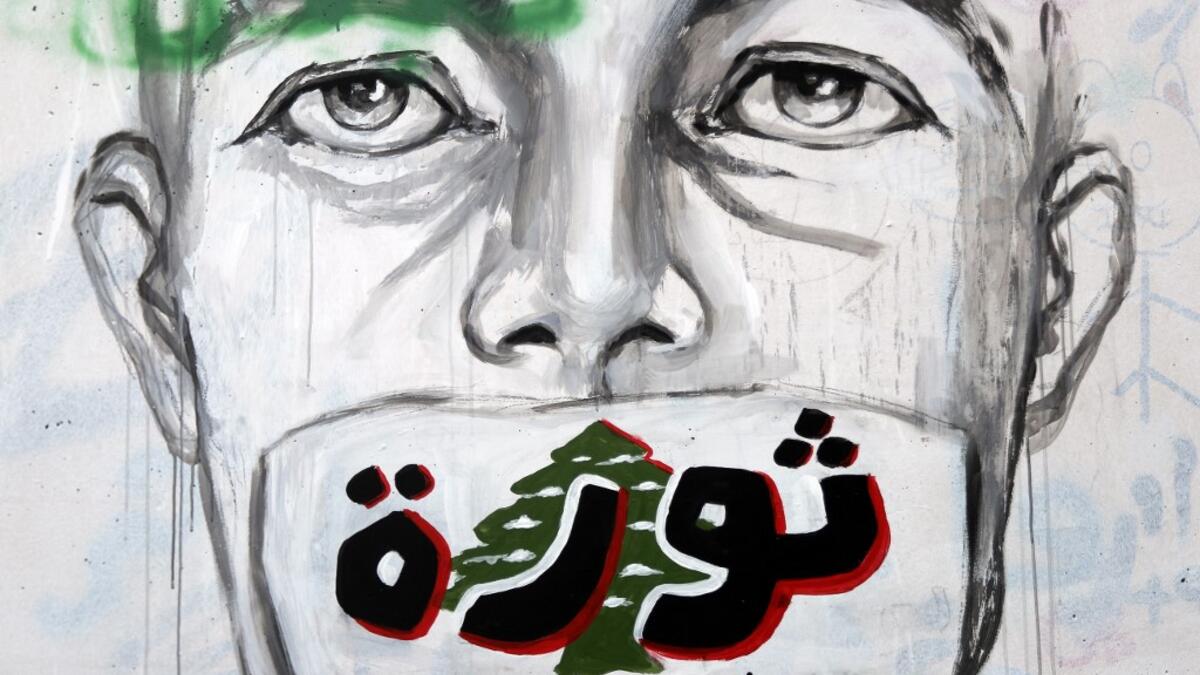 A graffiti reading "Revolution...even if you try to silence us" is sprayed on a wall in central Beirut on November 5, 2019. Since October 17, the chanting of tens of thousands of Lebanese denouncing the political elite have shaken the normally staid district around two Beirut squares, Martyrs' and Riad Al Solh. JOSEPH EID / AFP