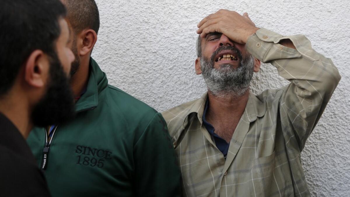 Palestinian men mourn outside the mortuary of Gaza City's Al-Shifa hospital on November 13, 2019, after two more Palestinians were killed in the morning in an Israeli strike, according to Gaza's health ministry, as Israel said it was targeting rocket-launching squads and militant sites. The deaths brought the Gaza toll to 18 people killed since an exchange of fire began on November 12 with an Israeli targeted strike on an Islamic Jihad commander sparking retaliatory rocket launches  ANAS BABA / AFP