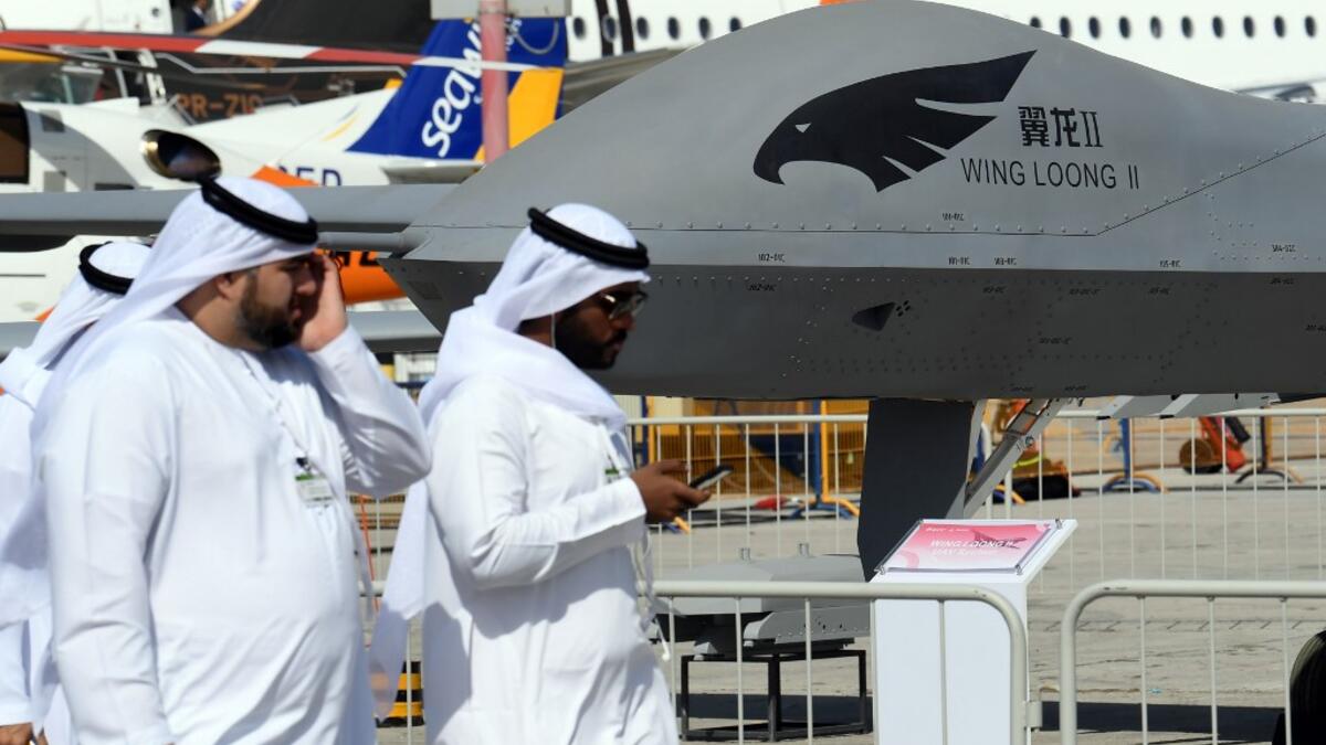 Men walk past a Chinese-made CAIG Wing Loong II medium altitude long endurance (MALE) unmanned aerial vehicle (UAV), on display during the 2019 Dubai Airshow on November 18, 2019. KARIM SAHIB / AFP