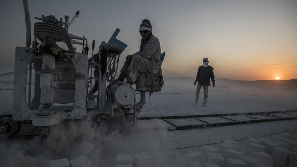 Labourers work at the "White Mountain" limestone extraction quarry site near Egypt's southern city of Minya, some 265 kilometres south of the capital, on November 13, 2019. Covered in fine white dust, labourers at the so-called "White Mountain" off Minya toil in shifts amidst brutal conditions with little workplace safety for paltry pay. They handle dangerous machinery with finesse, and shrug off the dangers of a job where a mistake can prove fatal. Khaled DESOUKI / AFP