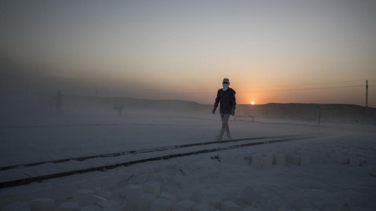 A labourer walks wearing protective gear at the "White Mountain" limestone extraction quarry site near Egypt's southern city of Minya, some 265 kilometres south of the capital, on November 13, 2019. Covered in fine white dust, labourers at the so-called "White Mountain" off Minya toil in shifts amidst brutal conditions with little workplace safety for paltry pay. They handle dangerous machinery with finesse, and shrug off the dangers of a job where a mistake can prove fatal. Khaled DESOUKI / AFP