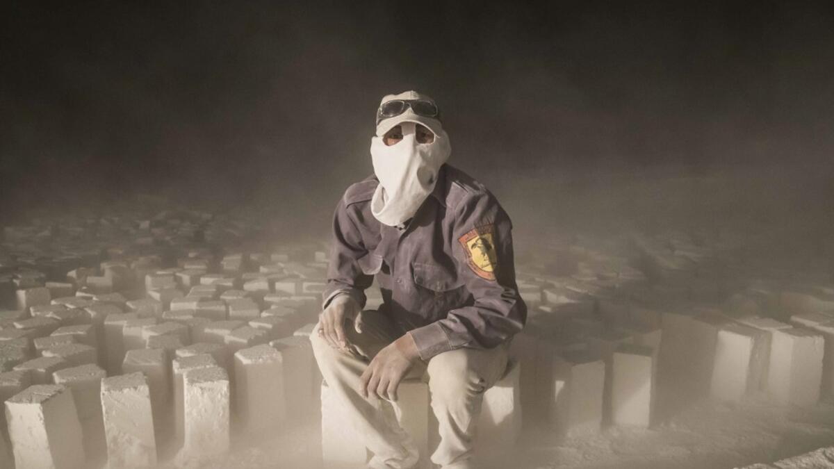 A labourer wearing protective gear poses for a picture while sitting on stone blocks while working late at night at the "White Mountain" limestone extraction quarry site near Egypt's southern city of Minya, some 265 kilometres south of the capital, on November 13, 2019. AFP