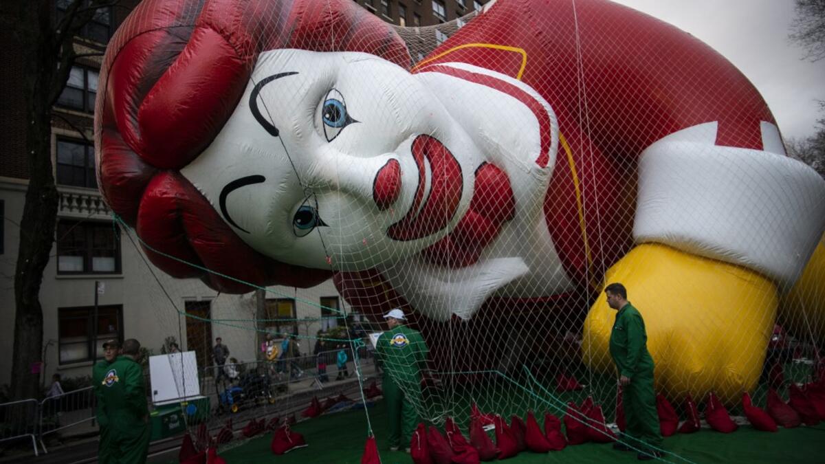 The Ronald McDonald balloon is kept under a net during the inflation process on November 27, 2019 in New York City. Winds could ground the giant balloons, according to city regulations, giant balloons cannot fly with gusts winds above 34 m.p.h. Eduardo Munoz Alvarez/Getty Images/AFP