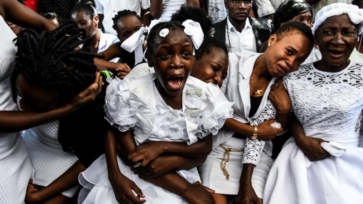 AFP PICTURES OF THE YEAR 2019 - A girl cries during her father's funeral organised by government opposition in Port-au-Prince, Haiti on October 16, 2019. The Haitian opposition on October 9 rejected President Jovenel Moise's appeal for dialogue, as the country's main cities remained paralyzed after more than a month of often violent protests. Over the past year, Haiti has sunk deeper into political crisis as anti-corruption protests demanding Moise's resignation roil the destitute Caribbean nation. CHANDAN