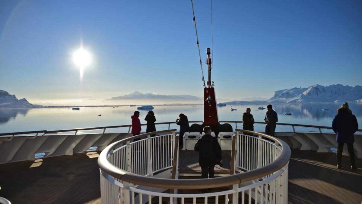 Tourists loot at the sunset from a ship at Chiriguano bay in the South Shetland Islands, Antarctica on November 07, 2019. Johan ORDONEZ / AFP
