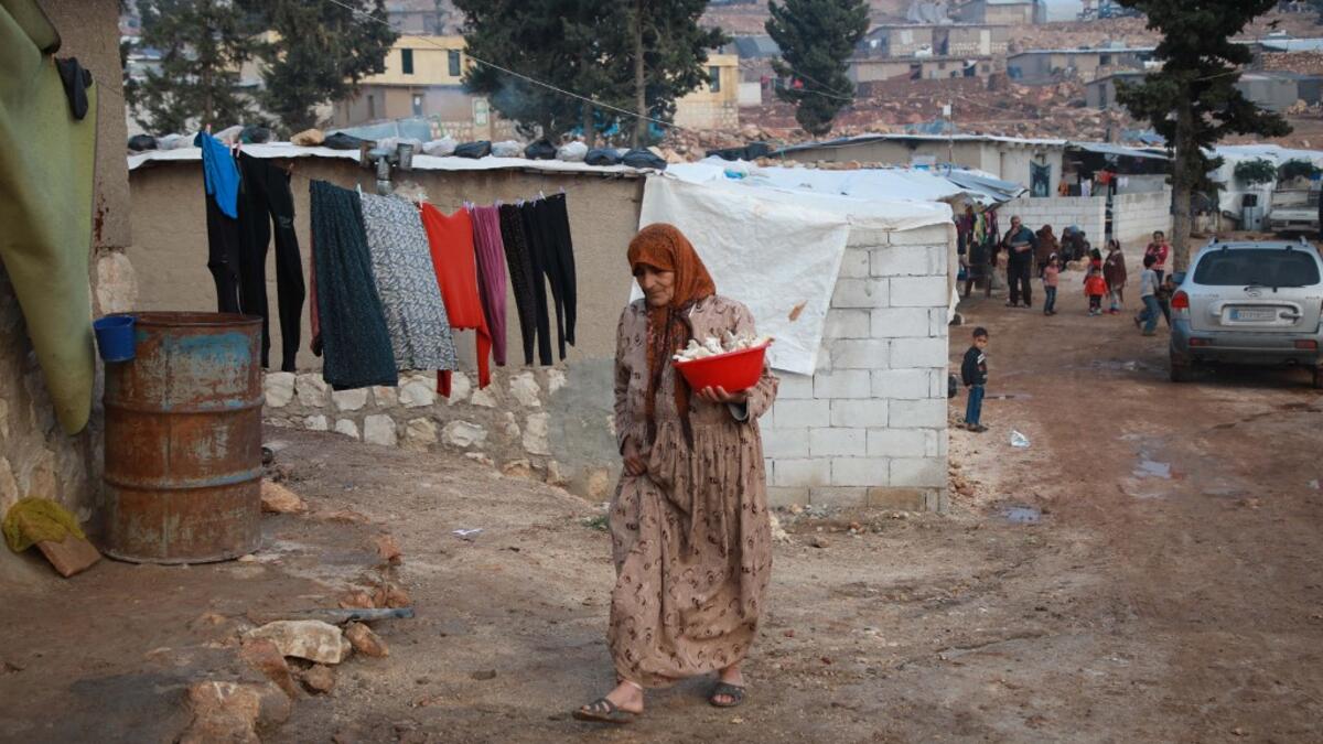 Umm Khaled cooks mushrooms in a pot in a camp in a town called Haarem in the northwestern province of Idlib on November 29, 2019. Aaref WATAD / AFP