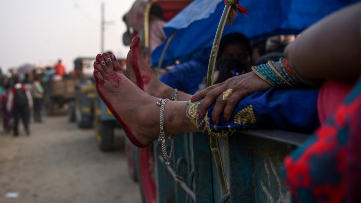 A devotee stretches her legs as she travels in a vehicle ahead of Gadhimai Festival in Baryarpur, 160 kms south of the Kathmandu, on December 2, 2019. Thousands of Hindu worshippers are flocking to a village in southern Nepal on December 2, defying court orders and calls by animal activists, in preparation for the world's biggest animal sacrifice. PRAKASH MATHEMA / AFP
