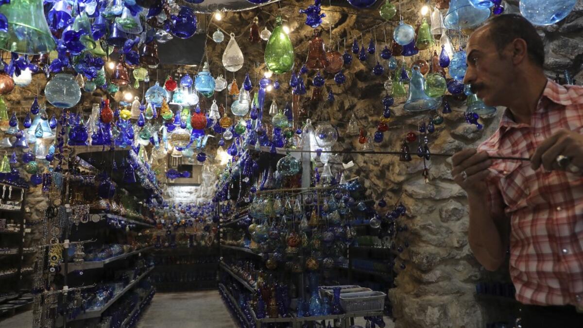 A Palestinian craftsman shapes molten glass into Christmas ornaments at his workshop in the southern West Bank city of Hebron, on December 15, 2019. HAZEM BADER / AFP