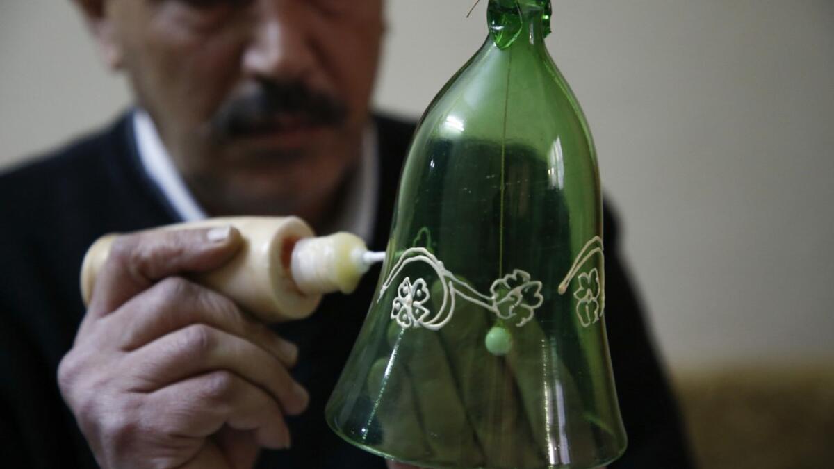 A Palestinian craftsman decorates a glass Christmas ornament at a workshop in the southern West Bank city of Hebron, on December 15, 2019. HAZEM BADER / AFP
