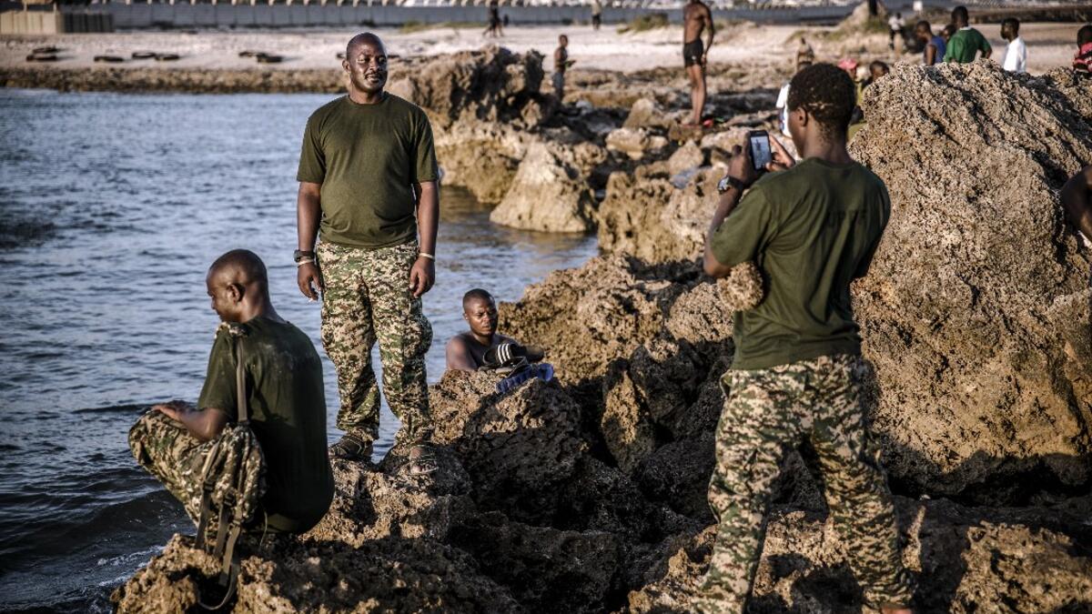 A group of UPDF (Uganda People Defence Forces) soldiers deployed in Somalia as part of the African Union peacekeeping take pictures while enjoying a day off by the beach within Mogadishu’s airport base in Mogadishu, Somalia, on December 13, 2019. LUIS TATO / AFP