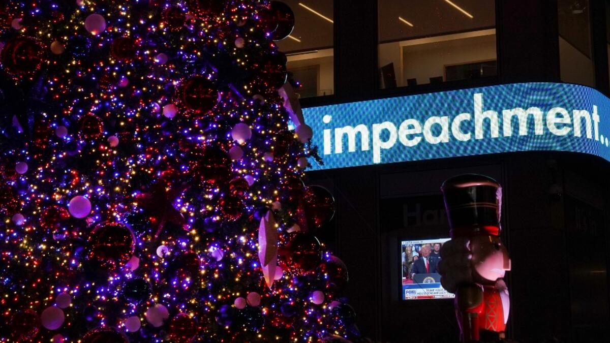 US President Donald Trump is shown on a screen speaking from a rally in Michigan as the the Fox News Headquarters ticker flashes the news of his impeachment for abuse of power in New York on December 18, 2019. US President Donald Trump was impeached for abuse of power in a historic vote in the House of Representatives on December 18, 2019, setting up a Senate trial on removing him from office after three turbulent years. TIMOTHY A. CLARY / AFP