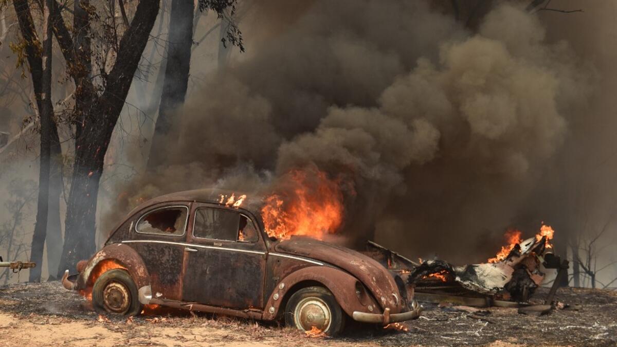 An old car burns from bushfires in Balmoral, 150 kilometres southwest of Sydney on December 19, 2019. A state of emergency was declared in Australia's most populated region on December 19, as a record heat wave fanned unprecedented bushfires. PETER PARKS / AFP