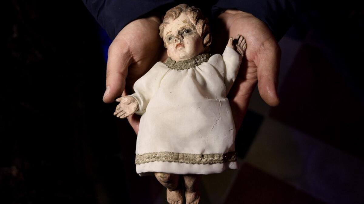 Volunteer Matteo Seia holds a nativity figure of Jesus, one of the most ancient figures of the 43rd edition of the "Presepio of Cavallermaggiore", a 300sqm Christmas Nativity crib in the Oratorio San Michele on December 20, 2019 in Cavallermaggiore, near Cuneo, Northwestern Italy. The "Presepio" is made by ten volunteers who every year spend 3 months to build a new edition with hundred of figures. MARCO BERTORELLO / AFP