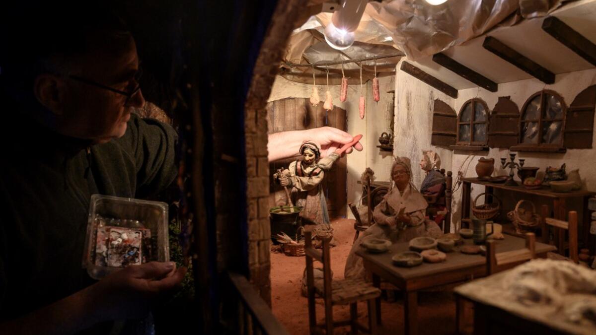 Volunteer Ilario Geuna cleans a nativity figure at the 43rd edition of the "Presepio of Cavallermaggiore", a 300sqm Christmas Nativity crib in the Oratorio San Michele on December 20, 2019 in Cavallermaggiore, near Cuneo, Northwestern Italy. The "Presepio" is made by ten volunteers who every year spend 3 months to build a new edition with hundred of figures. MARCO BERTORELLO / AFP