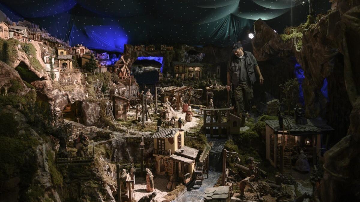 Volunteer Mario Curcetti walks through the "Presepio of Cavallermaggiore", a 300sqm Christmas Nativity crib in the Oratorio San Michele at its 43rd edition on December 20, 2019 in Cavallermaggiore, near Cuneo, Northwestern Italy. The "Presepio" is made by ten volunteers who every year spend 3 months to build a new edition with hundreds of figures. MARCO BERTORELLO / AFP