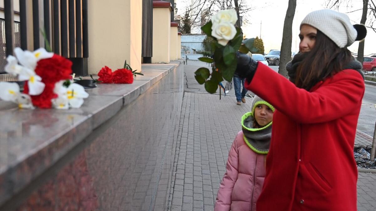 A woman with her daughter lay flowers outside the Canadian Embassy in Kiev on January 8, 2020 in remembrance of the victims of the Ukraine International Airlines Boeing 737-800 crash in the Iranian capital Tehran. A Ukrainian airliner carrying 176 people from seven countries crashed shortly after takeoff from Tehran on January 8, 2020 killing all on board. The vast majority of the passengers on the Boeing 737, which had been flying from Tehran to Kiev for Ukraine International Airlines, were Iranians and Ca