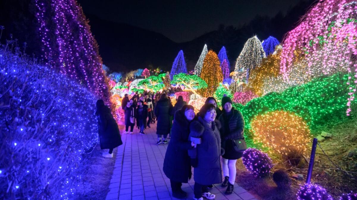In a photo taken on January 11, 2020 visitors look at an annual light display at the 'Garden on Morning Calm', near Gapyeong, east of Seoul. Ed JONES / AFP