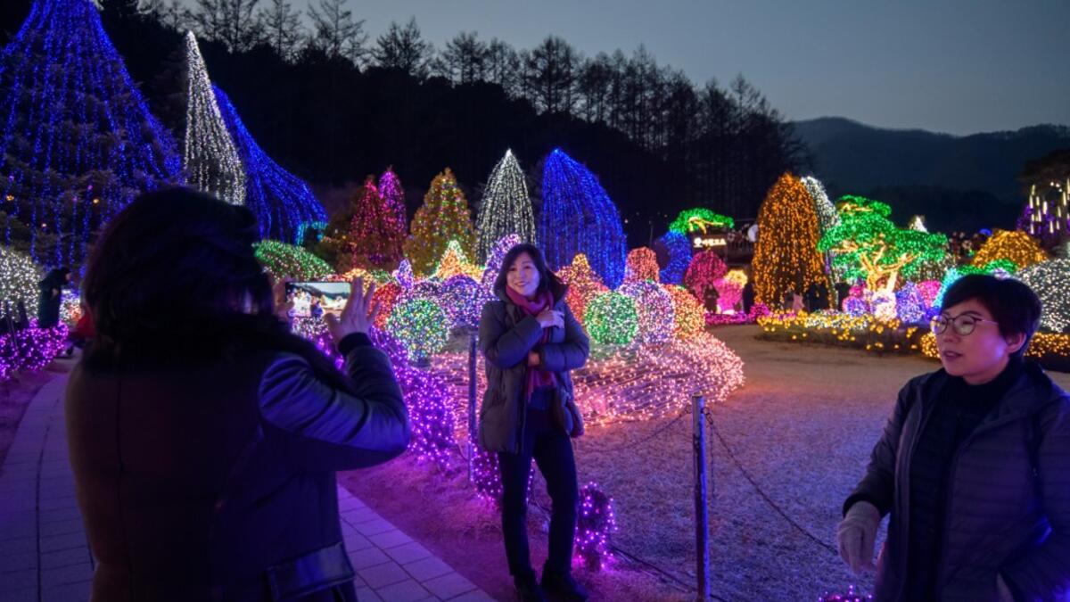In a photo taken on January 11, 2020 visitors look at an annual light display at the 'Garden on Morning Calm', near Gapyeong, east of Seoul. Ed JONES / AFP