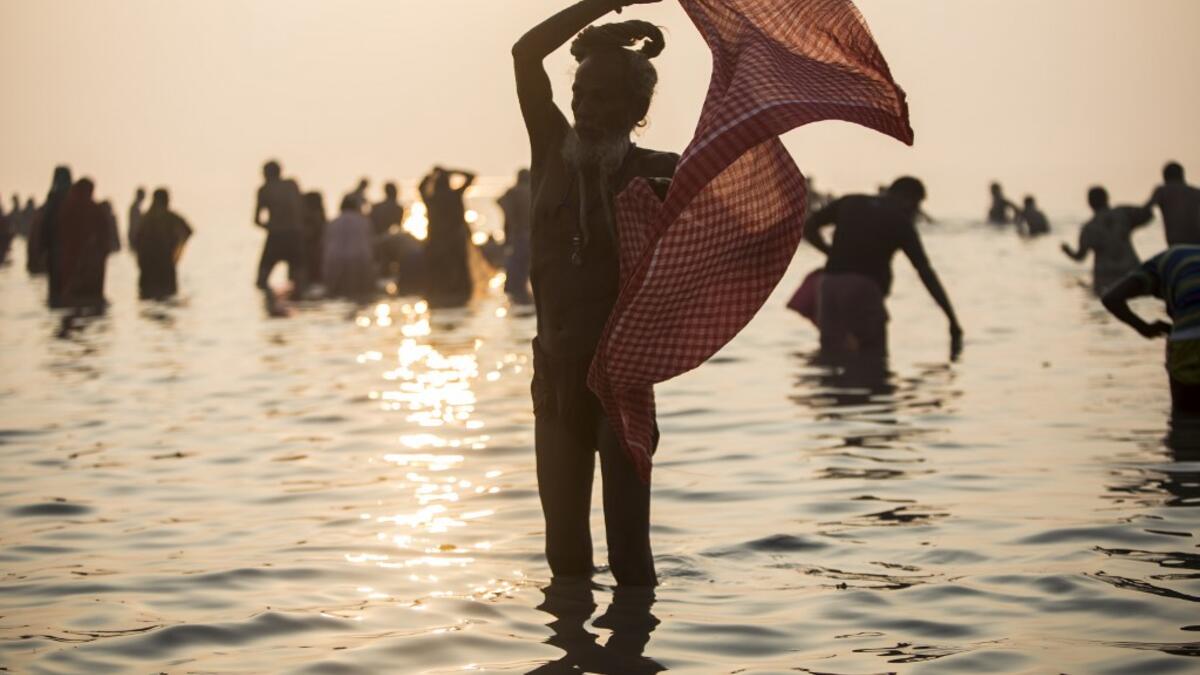 A Hindu Sadhu (holy man) takes a holy dip in the Bay of Bengal during the Gangasagar Mela, at Sagar Island, some 150 kilometres south of Kolkata on January 14, 2020. XAVIER GALIANA / AFP