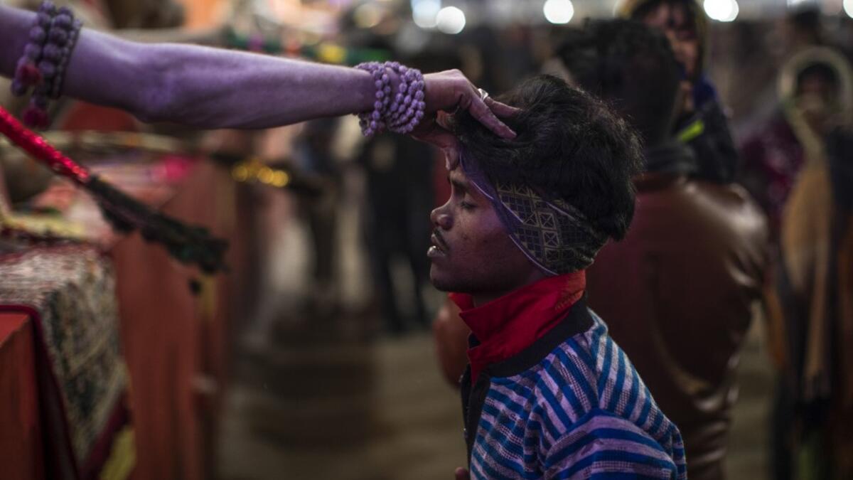 A Sadhu (Hindu holy man) blesses a pilgrim during the Gangasagar Mela, at Sagar Island, some 150 kilometres south of Kolkata on January 14, 2020. XAVIER GALIANA / AFP