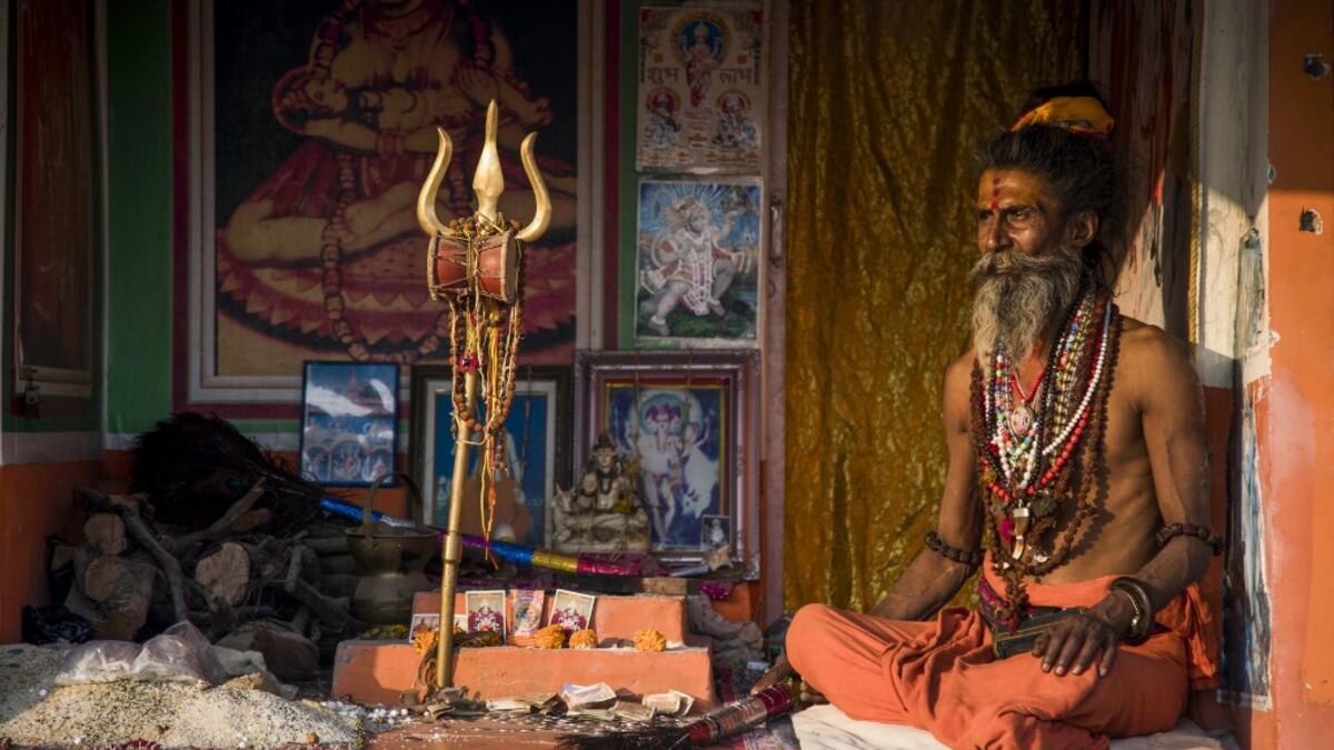 A Hindu Sadhu (holy man) waits to offer blessings to devotees at a temporary camp during the Gangasagar Mela, at Sagar Island, around 150 kilometres south of Kolkata on January 14, 2020. Xavier GALIANA / AFP