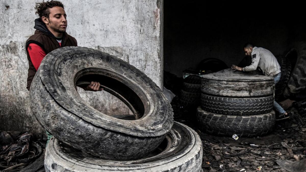Labourers transport stacked tyres at a rubber recycling workshop in the village of Mit al-Harun in Egypt's central Nile delta Gharbia Governorate, about 70 kilometres (43 miles) north of the capital, on January 14, 2020. Khaled DESOUKI / AFP