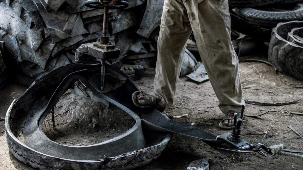 A labourer deconstructs a tyre at a rubber recycling workshop in the village of Mit al-Harun in Egypt's central Nile delta Gharbia Governorate, about 70 kilometres (43 miles) north of the capital, on January 14, 2020. Khaled DESOUKI / AFP