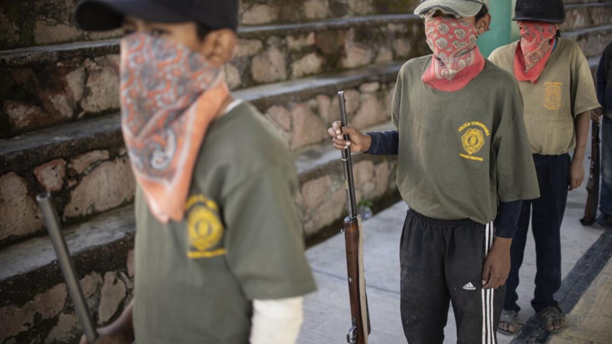 Children line up as thay are tought to use weapons by the Regional Coordinator of Community Authorities (CRAC-PF) community police force at a basketball court in the village of Ayahualtempan, Guerrero State, Mexico, on January 24, 2020. The CRAC-PF vigilante group trains children as young as five so they can protect themselves from drug-related criminal groups operating in the area. Pedro PARDO / AFP