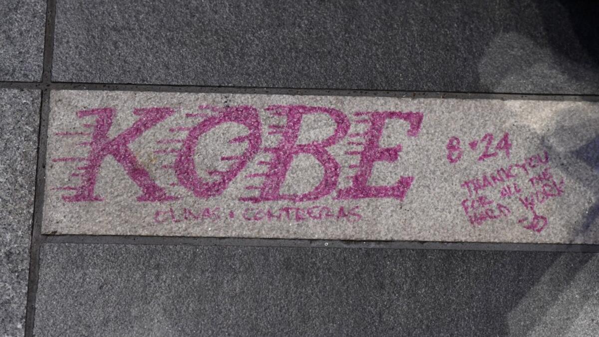 A note is written on the pavement as fans mourn the death of NBA legend Kobe Bryant, who was killed along with his daughter and seven others in a helicopter crash on January 26, at LA Live plaza in front of Staples Center in Los Angeles on January 27, 2020. Federal investigators sifted through the wreckage of the helicopter crash that killed basketball legend Kobe Bryant and eight other people, hoping to find clues to what caused the accident that stunned the world. Robyn Beck / AFP