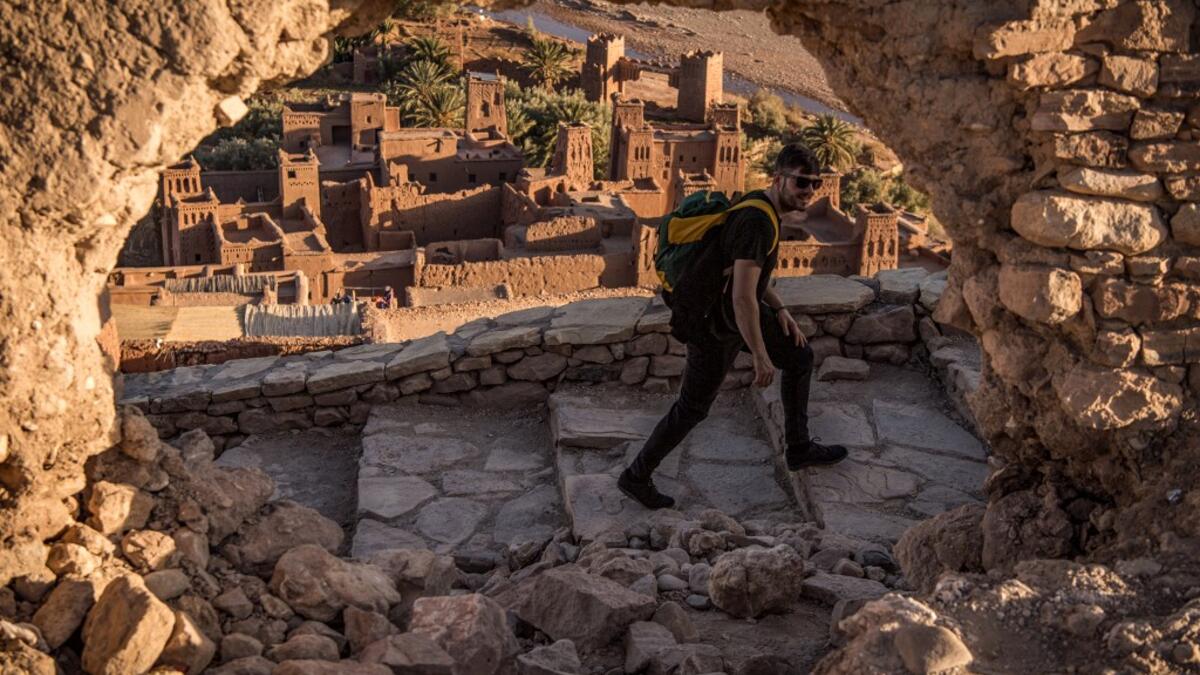 A tourist walks near the Kasbah (ancient fortress) of Ait-Ben-Haddou (background), where scenes depicting the fictional city of Yunkai from the hit HBO television series "Game of Thrones" were filmed, about 32 kilometres northwest of the city of Ouarzazate south of Morocco's High Atlas mountains on January 27, 2020. FADEL SENNA / AFP