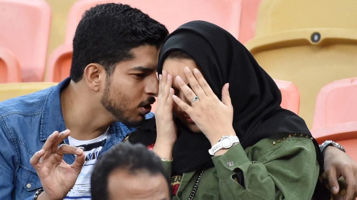 A picture taken on January 12, 2020 shows a Saudi couple attending a football match at King Abdullah Sport City Stadium in Jeddah. In Saudi Arabia's rigid past, religious police once swooped down on rose sellers and anyone peddling red paraphernalia around Valentine's Day, but now a more open -- albeit risky -- dating culture is taking root. Pursuing relationships outside of marriage in the conservative Islamic kingdom once amounted to a death wish, and would-be Romeos resorted to pressing phone numbers up