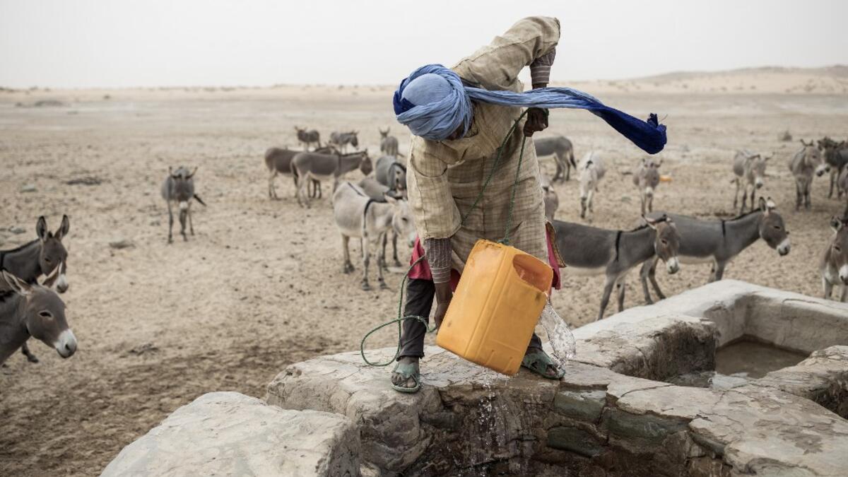 Ahmed(20), from the small Nemadi(hunters) tribe in Eastern Mauritania, pulls water out of one of the few water wells along the caravan route from Tichitt to Aratane in Mauritania on January 25, 2020. In the arid West African country of Mauritania, the way of life of the traditional group of hunters known as the Nemadi is slowly disappearing. JOHN WESSELS / AFP