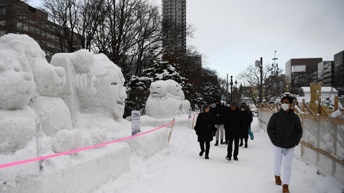 People visit the Sapporo Snow Festival in Sapporo on February 4, 2020. The snow festival, which opened January 31 in the capital of Hokkaido in northern Japan, is a major draw for the region, attracting more than 2.7 million visitors last year. Organisers for this year's festival were forced to truck in an unprecedented amount of extra powder to build their signature sculptures after an unseasonably warm winter.  CHARLY TRIBALLEAU / AFP
