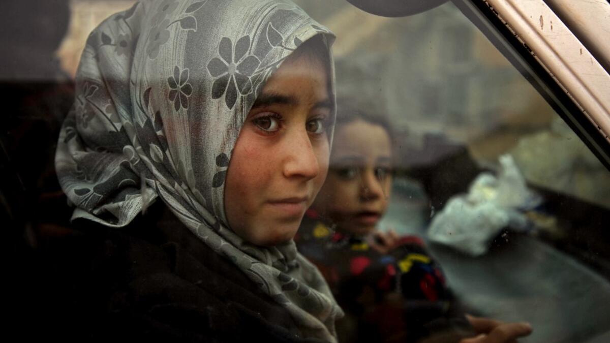 Displaced Syrian girls look on from within a vehicle passing through the town of Hazano in the northern countryside of Idlib, on February 4, 2020, fleeing northwards amid an ongoing regime offensive. A Russian-backed Syrian government offensive against the country's last rebel enclave of Idlib has displaced more than half a million people in two months, according to the United Nations. The wave of displacement, which coincides with a biting winter, is one of the largest since the start of the Syrian war nea